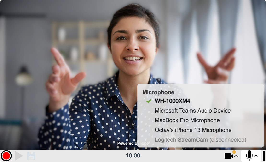 A screenshot of the addpipe.com recording client interface capturing a woman raising her arms and recording herself. The recording client's audio device selector menu is open and it displays all the available audio devices that can be recorder, and also an audio device that is now disconnected