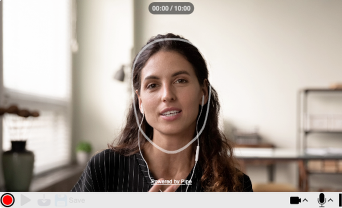 A woman wearing headphones is recording herself speaking using addpipe's recording client with the face positioning outline feature turned on